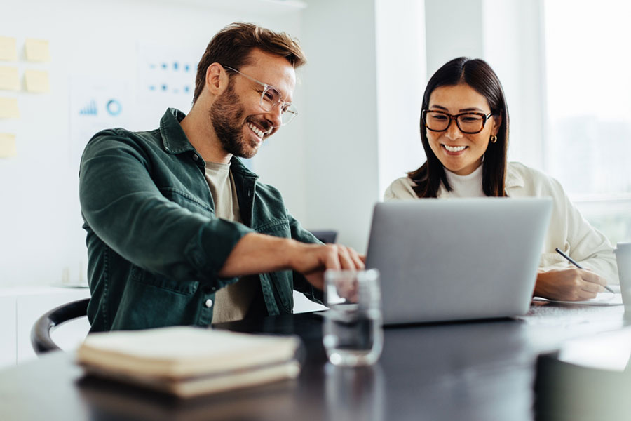 Collègues de travail en train d'utiliser des outils d'intelligence artificielle comme ChatGPT dans leur travail quotidien pour gagner du temps